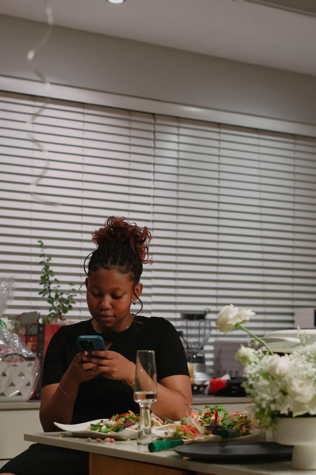 Picture of a young woman on her phone at a dinner